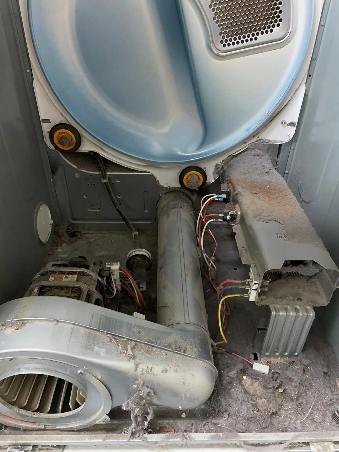 Heavy lint buildup inside a residential dryer before preventive maintenance